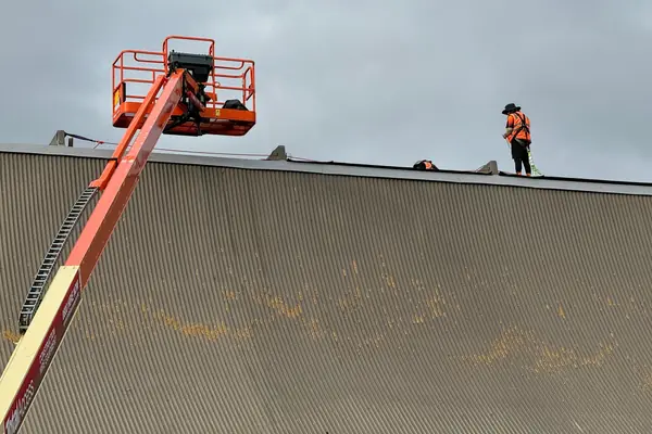 Cherry picker providing safe access for work on a long-run metal roof