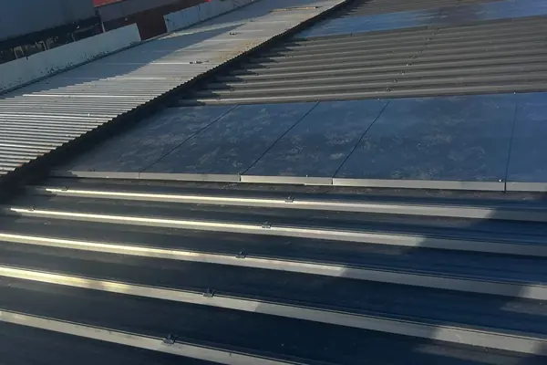 New dark long-run steel roof sheets running to the gutter line