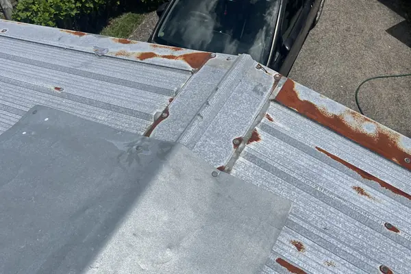 Corrugated iron roof with new galvanised flashing fitted where it meets the wall